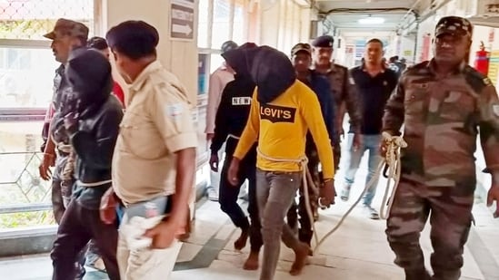 Police personnel escort men accused for allegedly carrying out a brutal assault on a Spanish woman, to a district court in Dumka, (AFP)