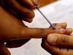 A polling official marks a voter with indelible ink. A polling official marks a voter with indelible ink.