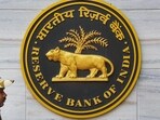 A security official walks past an emblem of the Reserve Bank of India at the RBI headquarters, in Mumbai. A security official walks past an emblem of the Reserve Bank of India at the RBI headquarters, in Mumbai.