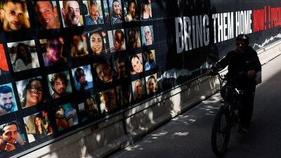 A person rides a bicycle past photos of hostages who were kidnapped in the deadly October 7 attack on Israel by the Palestinian Islamist group Hamas from Gaza, in Tel Aviv, Israel March 6, 2024. REUTERS/Carlos Garcia Rawlins (REUTERS)