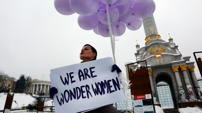 FILE - A woman holds balloons and a poster to mark International Women's Day in central Kiev, Ukraine, March 8, 2018. Women across the world will demand equal pay, reproductive rights, education, justice and other essential needs during demonstrations marking International Women’s Day on Friday, March 8, 2024. (AP Photo/Efrem Lukatsky, File) (AP) FILE - A woman holds balloons and a poster to mark International Women's Day in central Kiev, Ukraine, March 8, 2018. Women across the world will demand equal pay, reproductive rights, education, justice and other essential needs during demonstrations marking International Women’s Day on Friday, March 8, 2024. (AP Photo/Efrem Lukatsky, File) (AP)