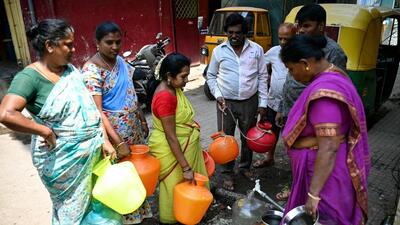 Local residents gather to fill cans of water from a municipal tap in Bengaluru on Thursday. (AFP) Local residents gather to fill cans of water from a municipal tap in Bengaluru on Thursday. (AFP)