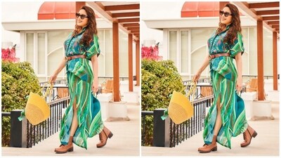 Her outfit comes in a vibrant shade of green and features a chic shirt adorned with chintz-inspired patterns. She teamed it with a matching pair of flared trousers with an intriguing high side slit for a sassy look. (Instagram/@madhuridixitnene) Her outfit comes in a vibrant shade of green and features a chic shirt adorned with chintz-inspired patterns. She teamed it with a matching pair of flared trousers with an intriguing high side slit for a sassy look. (Instagram/@madhuridixitnene)