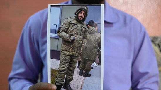 This photo taken on February 22, 2024, shows a picture printout of Indian national Mohammed Asfan, seen wearing Russian military fatigues who last called family from the southern Russian city of Rostov-on-Don before being deployed amid the conflict in Ukraine. (AFP)