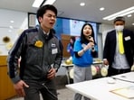 Masaya Shibasaki, 26, an employee of EXEO Group Inc., reacts as he tries the Osaka Heart Cool developed VR electrical device 'Perionoid' which releases electrical stimulation that feels like experiencing women's menstrual pain during a workshop ahead of the International Women's Day at the company headquarters in Tokyo, Japan 