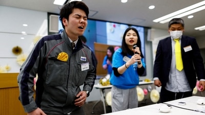 Masaya Shibasaki, 26, an employee of EXEO Group Inc., reacts as he tries the Osaka Heart Cool developed VR electrical device 'Perionoid' which releases electrical stimulation that feels like experiencing women's menstrual pain during a workshop ahead of the International Women's Day at the company headquarters in Tokyo, Japan (REUTERS)