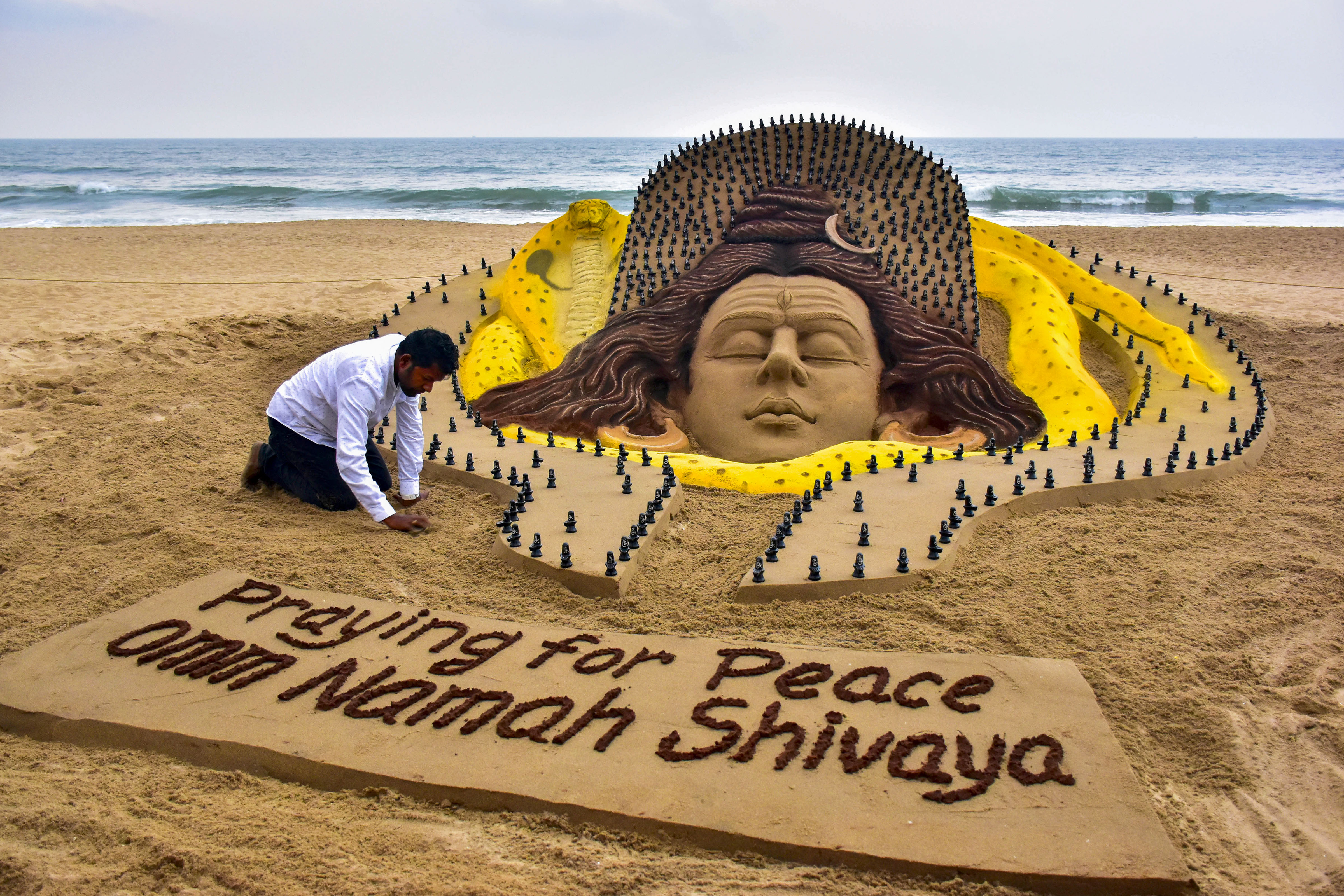 Sand artist Sudarshan Pattanaik creates a sculpture on Lord Shiva ahead of 'Maha Shivaratri' festival, in Puri, (PTI) Sand artist Sudarshan Pattanaik creates a sculpture on Lord Shiva ahead of 'Maha Shivaratri' festival, in Puri, (PTI)