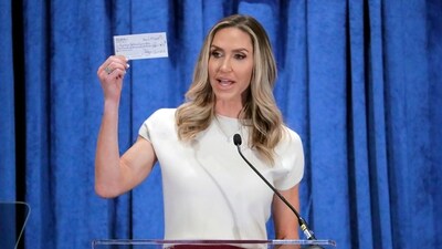 Lara Trump, the newly-elected co-chair of the Republican National Committee, holds up a donation check as she gives an address during the general session of the RNC Spring Meeting Friday, March 8, 2024, in Houston. (AP Photo/Michael Wyke) (AP)