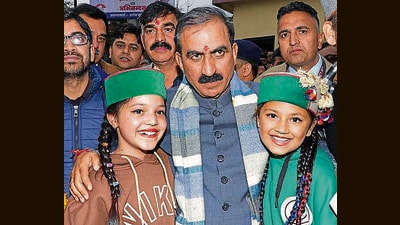 Himachal CM Sukhvinder Singh Sukhu poses for a picture with children during his visit to Darlaghat in Solan on Sunday (HT Photo)