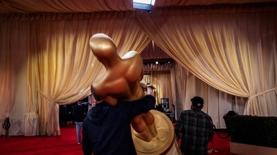 Workers carry an Oscar statue as preparations continue. The Best Picture award will be announced last, as has been the custom. (REUTERS)