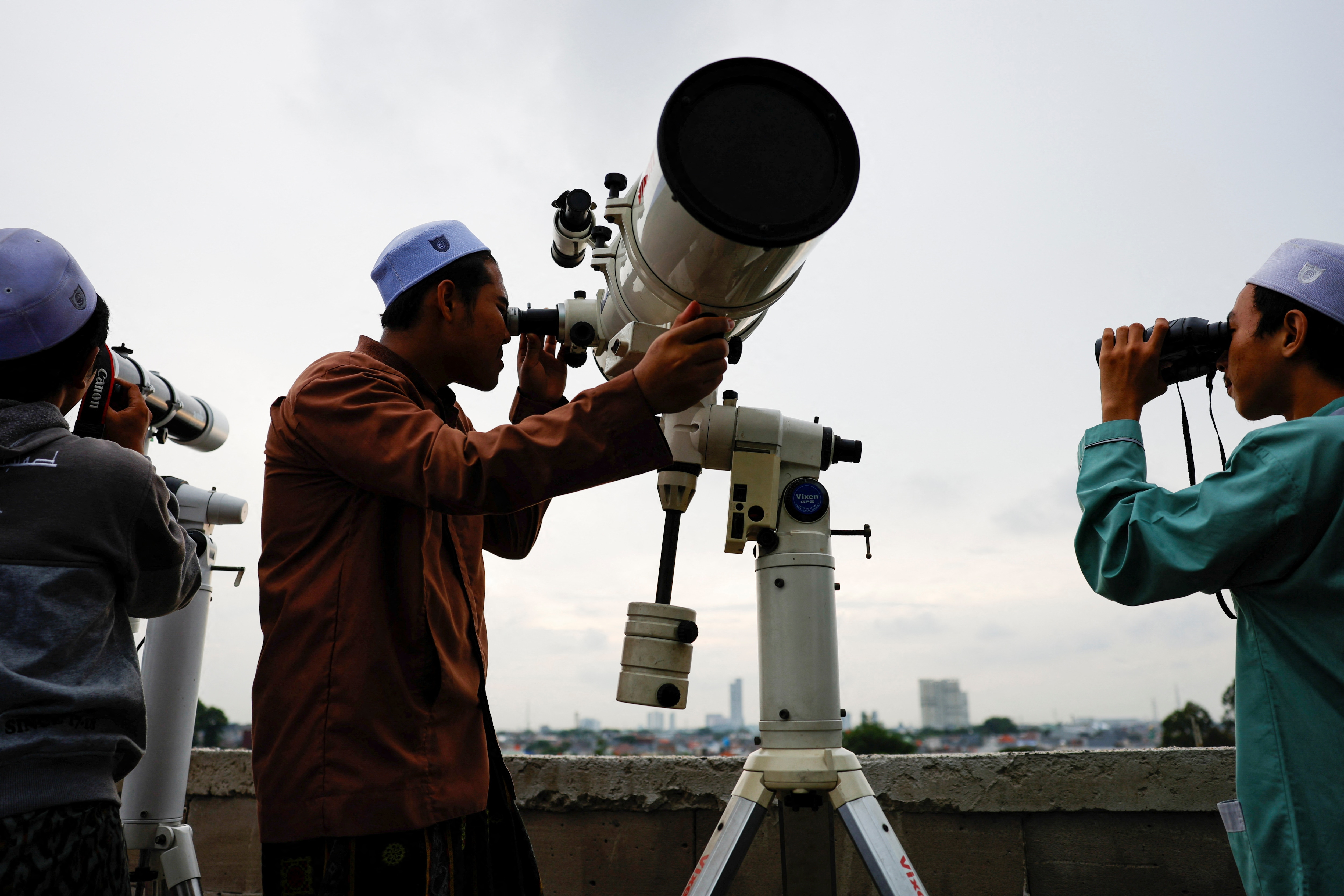 Muslim men look for the position of the moon to mark the first day of the holy fasting month of Ramadan, on the roof of Al-Musyari'in mosque in Jakarta, Indonesia, March 10, 2024.  (Photo by REUTERS/Willy Kurniawan)