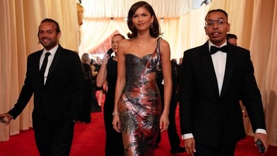 Zendaya brought glitz and glamour to the Oscars red carpet in a metallic pink corest gown, made from antique rose silk and featuring a metallic single strap over a glittering black corset embellished with gunmetal paillettes. The rest of the rose gold dress featured a retro embroidered palm tree pattern adding a glam touch. (John Locher/Invision/AP) Zendaya brought glitz and glamour to the Oscars red carpet in a metallic pink corest gown, made from antique rose silk and featuring a metallic single strap over a glittering black corset embellished with gunmetal paillettes. The rest of the rose gold dress featured a retro embroidered palm tree pattern adding a glam touch. (John Locher/Invision/AP)