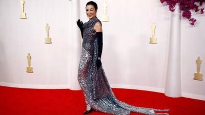 Michelle Yeoh stunned in a custom Balenciaga Couture gown and sleek black opera gloves. The metallic silver sequined one-shoulder gown features a one-shoulder neckline, a train at the back, and a form-fitting silhouette. She styled the dress with glittery leaf-shaped earrings designed by Cindy Chao.&nbsp; (REUTERS)