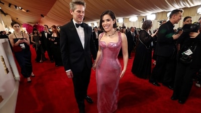 America Ferrera and Ryan Piers Williams pose on the red carpet at the Oscars 2024. She wore a pink sequinned Versace gown for the occasion.&nbsp; (REUTERS)