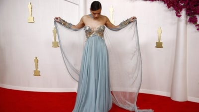 Hailee Steinfeld poses on the red carpet at the 2024 Academy Awards in an eye-catching ice blue gown with an off-the-shoulder sweetheart neckline, gold embellishments on the bust and a flared bottom. The matching fabric wrapped around her neck added a touch of wow factor. (REUTERS)