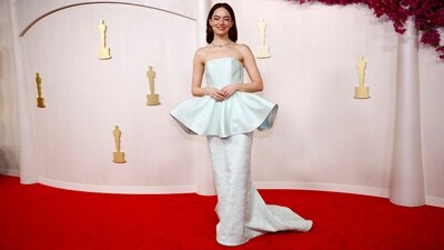 Emma Stone, nominated as Best Actress for her performance in Poor Things, wore a custom Louis Vuitton gown to the Oscars red carpet. Her textured mint green dress features a strapless neckline, a corseted bodice, a peplum waist, shell detailing, and a floor-length hem. Diamond rings, a choker necklace adorned with a yellow diamond, dainty earrings, centre-parted auburn hair, and minimal glam rounded off her look.&nbsp; (REUTERS)