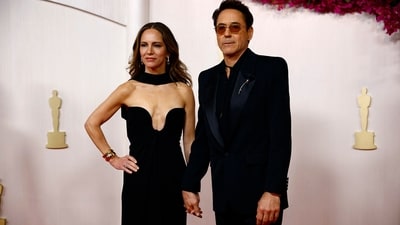 Robert Downey Jr and Susan Downey arrived on the Oscars red carpet in stylish black outfits. He graced the show in a dapper Saint Laurent suit, while Susan Downey looked glamorous in a plunging neckline, off-the-shoulder black gown with an attached fabric collar around her neck. (REUTERS/Sarah Meyssonnier)