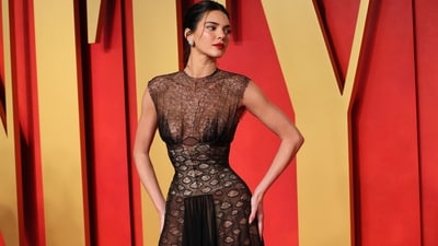 Kendall Jenner attended the Vanity Fair Oscars after-party in a Maison Margiela sheer detailed gown, becoming one of the stars who embraced the trend at the event. She styled it with red lips, a sleek bun, diamond earrings, and high heels.&nbsp; (REUTERS)