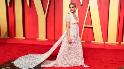 Jennifer Lawrence attended the Vanity Fair Oscars party in an elegant Givenchy couture gown - modelled by Kate Moss in 1996. The sheer white floor-length ensemble features an Empire silhouette, a plunging neckline, floral lace work, and a train at the back.&nbsp; (REUTERS)