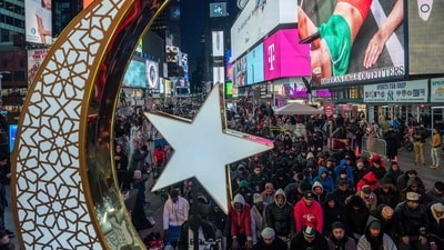 Organizers projected prayers from the Quran onto a white sheet that fluttered in the wind, juxtaposed against giant advertisements for Broadway musicals and candy glowing overhead.&nbsp; (AFP)