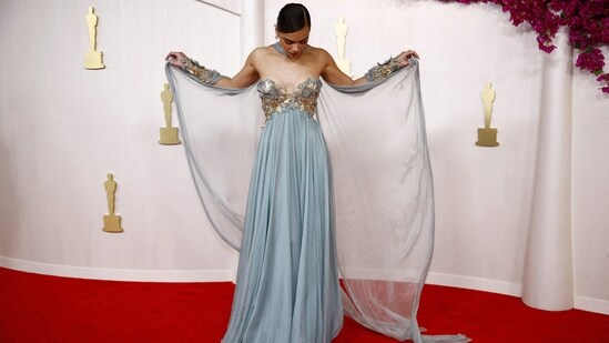 Hailee Steinfeld poses on the red carpet at the 2024 Academy Awards in an eye-catching ice blue gown with an off-the-shoulder sweetheart neckline, gold embellishments on the bust and a flared bottom. The matching fabric wrapped around her neck added a touch of wow factor.(REUTERS)