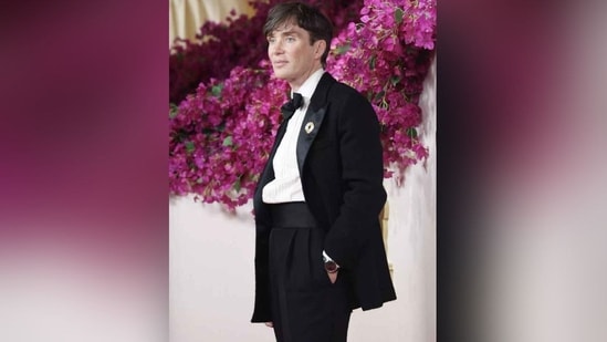 Oppenheimer nominee Cillian Murphy opted for classic elegance at this year's Oscars, wearing a black tuxedo. He accessorised his look with a black silk cummerbund, a silver flower brooch, an Omega watch and a floppy silk bow tie.(REUTERS)