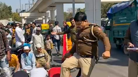 Delhi A police sub-inspector kicks men who were offering namaz on the road in Inderlok area, in New Delhi, Friday, March, 8, 2024. (PTI)