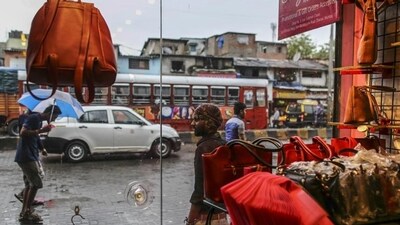 Passing pedestrians and traffic are seen through the window of a leather goods stores in the Dharavi area of Mumbai.