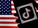 (FILES) In this photo illustration, the social media application logo, TikTok is displayed on the screen of an iPhone on an American flag background on August 3, 2020 in Arlington, Virginia. The US House of Representatives overwhelmingly approved a bill on March 13, 2024 that would force Tiktok to divest from its Chinese owner or get banned from the United States. (Photo by Olivier DOULIERY / AFP)