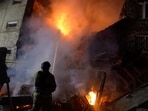 Rescuers work to extinguish fire at a building due to a drone attack.