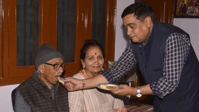 The parents of newly appointed election commissioner Gyanesh Kumar being offered sweets at their home at Vijay Nagar Colony in Agra. (HT Photo)