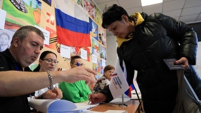 A woman registers to vote in Russia's presidential election in Simferopol, Crimea, (AFP)