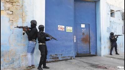 National Police stand guard outside the empty National Penitentiary after a small fire inside in downtown Port-au-Prince, Haiti, on March 14. This is the same facility that armed gangs stormed late March 2 and hundreds of inmates escaped. (AP) National Police stand guard outside the empty National Penitentiary after a small fire inside in downtown Port-au-Prince, Haiti, on March 14. This is the same facility that armed gangs stormed late March 2 and hundreds of inmates escaped. (AP)