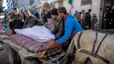 Palestinians use a donkey-pulled cart to transport the body of a relative killed in Israeli bombardment (AFP)