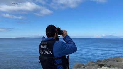 A coast guard officer looking through binoculars as a drone searches for victims (AFP) A coast guard officer looking through binoculars as a drone searches for victims (AFP)