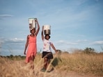 Residents of Pumula East township walk home after fetching water from a well, as temperatures soar during an El Nino-related heatwave and drought affecting a large part of the country, in Bulawayo, Zimbabwe March 7, 2024. REUTERS/KB Mpofu