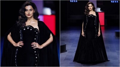 Taapsee Pannu stunned as showstopper for LG MoodUP presents Gauri & Nainika. Her look was all about gothic chic as she donned an all-black ensemble. Her off-the-shoulder black gown had silver embellishments and a fish-tail hemline which gave it a trendy look. It was topped off with a long cape that perfectly complemented her look. With bold red lips and her hair in a side parting, she looked just wow. (Instagram/@lakmefashionwk) Taapsee Pannu stunned as showstopper for LG MoodUP presents Gauri & Nainika. Her look was all about gothic chic as she donned an all-black ensemble. Her off-the-shoulder black gown had silver embellishments and a fish-tail hemline which gave it a trendy look. It was topped off with a long cape that perfectly complemented her look. With bold red lips and her hair in a side parting, she looked just wow. (Instagram/@lakmefashionwk)