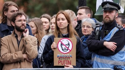 A person holds a placard against incumbent Russian President Vladimir Putin, on the final day of the presidential election in Russia, (REUTERS)