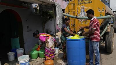 Residents of Ambedkar Nagar in Whitefield locality collect potable water from a private tanker in Bengaluru on March 11. (AP)