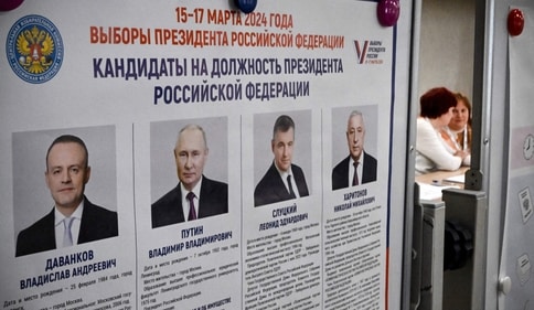 Members of a local electoral commission sit next to an information billboard showing the candidates in Russia's presidential election at a polling station in Sergiyev Posad, some 75 kilometres (47 miles) north-east from Moscow, on March 16, 2024. (AFP) Members of a local electoral commission sit next to an information billboard showing the candidates in Russia's presidential election at a polling station in Sergiyev Posad, some 75 kilometres (47 miles) north-east from Moscow, on March 16, 2024. (AFP)