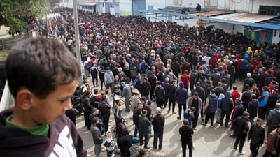 Palestinians gather to receive aid outside an UNRWA warehouse as Gaza residents face crisis levels of hunger, amid the ongoing conflict between Israel and Hamas, (REUTERS)