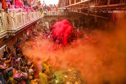 Devotees play with colours during Ladoo Holi celebrations at the Sriji temple in Barsana, near Mathura. (PTI) Devotees play with colours during Ladoo Holi celebrations at the Sriji temple in Barsana, near Mathura. (PTI)