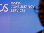 TCS share price: A man walks past a logo of Tata Consultancy Services (TCS) before a press conference.