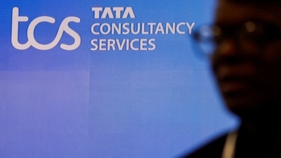 TCS share price: A man walks past a logo of Tata Consultancy Services (TCS) before a press conference. (Reuters)