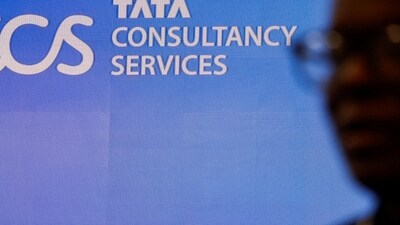 TCS salary hike: A man walks past a logo of Tata Consultancy Services (TCS) before a press conference. (Reuters)