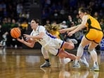 South Dakota State guard Paige Meyer (21) falls while driving between North Dakota State players during an NCAA college basketball game for the Summit League women's tournament championship Tuesday, March 12, 2024, in Sioux Falls, S.D. (Samantha Laurey/The Argus Leader via AP)