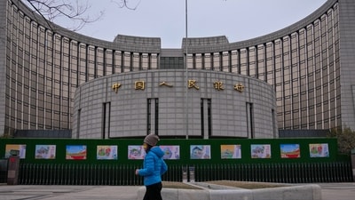 A woman jogs past China's central bank, or the People's Bank of China in Beijing. (AP)