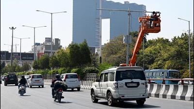 Noida authority staff install the new cameras on elevated road. They will start working in a week, said traffic police. (Sunil Ghosh/HT Photo) Noida authority staff install the new cameras on elevated road. They will start working in a week, said traffic police. (Sunil Ghosh/HT Photo)