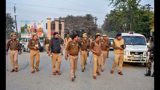 Senior police officials visit the locality where a barber killed two boys in Budaun district on Wednesday (PTI)