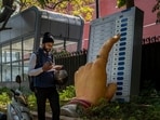A man walks past a large model of a woman's finger pressing a button of an electronic voting machine displayed outside the office of the Election Commission of India A man walks past a large model of a woman's finger pressing a button of an electronic voting machine displayed outside the office of the Election Commission of India